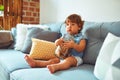 Beautiful toddler child girl holding jar of cookies sitting on the sofa Royalty Free Stock Photo