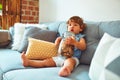 Beautiful toddler child girl holding jar of cookies sitting on the sofa Royalty Free Stock Photo