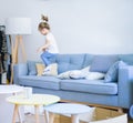 Beautiful toddler child girl jumping on the sofa Royalty Free Stock Photo