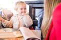 Beautiful toddler child girl sitting on baby highchair crying front of a woman