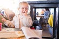 Beautiful toddler child girl sitting on baby highchair crying and screaming