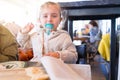 Beautiful toddler child girl sitting on baby highchair crying using pacifier