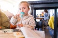 Beautiful toddler child girl sitting on baby highchair crying using pacifier