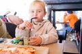 Beautiful toddler child girl sitting on baby highchair drinking juice using straw with happy face Royalty Free Stock Photo