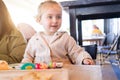 Beautiful toddler child girl sitting on baby highchair  playing with toys on the table Royalty Free Stock Photo