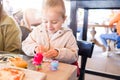 Beautiful toddler child girl sitting on baby highchair  playing with toys on the table Royalty Free Stock Photo
