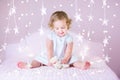 Beautiful toddler girl with curly hair between Christmas lights Royalty Free Stock Photo