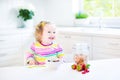 Beautiful toddler girl having breakfast drinking juice Royalty Free Stock Photo