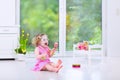 Beautiful toddler girl playing maracas in white room