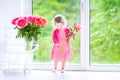 Beautiful toddler girl playing with peony flowers Royalty Free Stock Photo