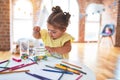 Beautiful toddler standing playing with chocolate colored balls on the table at kindergarten Royalty Free Stock Photo