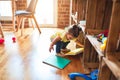 Beautiful toddler taking books of shelving at kindergarten