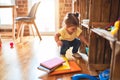 Beautiful toddler taking books of shelving at kindergarten