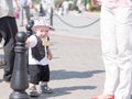 Beautiful toddler walking with his mother on a city holiday. Kid stylishly dressed butterfly and cap Royalty Free Stock Photo