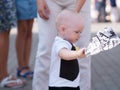 Beautiful toddler walking with his mother on a city holiday. Kid stylishly dressed butterfly and cap Royalty Free Stock Photo