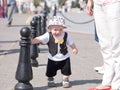 Beautiful toddler walking with his mother on a city holiday. Kid stylishly dressed butterfly and cap Royalty Free Stock Photo