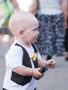 Beautiful toddler walking with his mother on a city holiday. Kid stylishly dressed butterfly and cap. Boy holding Royalty Free Stock Photo