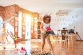 Beautiful toddler wearing glasses and unicorn diadem standing holding tractor at kindergarten