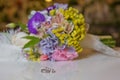 Beautiful toned picture with Engagement rings lie on a wooden surface against the background of a bouquet of flowers . wedding Royalty Free Stock Photo