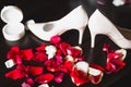 Beautiful toned picture with wedding rings on wedding shoes against the background of flowers Royalty Free Stock Photo