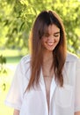 Beautiful toothy smiling teen woman looking happy outdoors summer green trees background. Closeup portrait Royalty Free Stock Photo