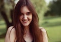 Beautiful toothy smiling teen woman looking happy outdoors on summer green trees background. Closeup portrait in bright sunny day Royalty Free Stock Photo