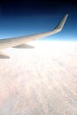Beautiful top view from passenger supersonic airplane window flying high above white clouds in the sky Royalty Free Stock Photo