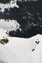 beautiful top view of the snow-capped mountain slope and evergreen trees and the house below Royalty Free Stock Photo