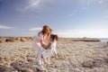 Beautiful top view of young mother playing with daughter with white hat at the sea background. Family vacation. Travel. Female Royalty Free Stock Photo
