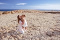 Beautiful top view of young mother playing with daughter with white hat at the sea background. Family vacation. Travel. Female Royalty Free Stock Photo