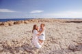 Beautiful top view of young mother playing with daughter with white hat at the sea background. Family vacation. Travel. Female Royalty Free Stock Photo