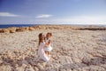 Beautiful top view of young mother playing with daughter with white hat at the sea background. Family vacation. Travel. Female Royalty Free Stock Photo