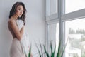 Beautiful topless girl covered up with a jacket and stands near the window Royalty Free Stock Photo