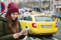 Beautiful tourist girl with a tablet on a street in Prague calls a taxi or looks at a map or uses the Internet or a Royalty Free Stock Photo