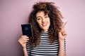 Beautiful tourist woman with curly hair and piercing holding australia australian passport id surprised with an idea or question