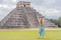 Beautiful tourist woman observing the old pyramid and temple of the castle of the Mayan architecture known as Chichen