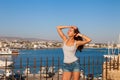 Beautiful tourist woman on the old castle on Mediterranean sea coast. Paphos, Cyprus. Bright sunset light Royalty Free Stock Photo