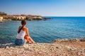 Beautiful tourist woman on the old castle on Mediterranean sea coast. Paphos, Cyprus. Bright sunset light Royalty Free Stock Photo