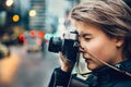 Beautiful tourist woman taking photo with vintage old camera in the city