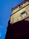 Beautiful tower of an old stone house on a background of blue almost cloudless sky Royalty Free Stock Photo