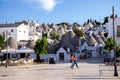 Beautiful town of Alberobello with typical trulli houses built from stone among green plants and flowers, main touristic district