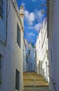 Beautiful traditional andalusian white village, empty lonely alley with stone steps uphill, old houses, blue sky - Arcos de la
