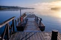 Beautiful tranquil scene of a pier in the sea with fog Royalty Free Stock Photo