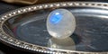 Beautiful translucent sphere resting on an ornate silver tray reflecting soft light and textures indoors Royalty Free Stock Photo