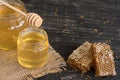 Beautiful transparent honey in bank, honeycombs and pollen on a wooden table Royalty Free Stock Photo