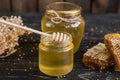 Beautiful transparent honey in bank, honeycombs and pollen on a wooden table Royalty Free Stock Photo