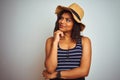 Beautiful transsexual transgender woman wearing summer hat over isolated white background with hand on chin thinking about Royalty Free Stock Photo