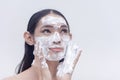 A beautiful transwoman washes her face with a foamy whitening facial cleanser. Beauty products and cosmetics endorser. Royalty Free Stock Photo