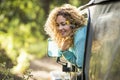 Beautiful travel concept adult woman enjoy the forest sit down inside a car and outside the window - adventure and alternaive Royalty Free Stock Photo