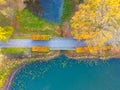 Beautiful travel or tourism style look down aerial of pedestrian foot bridge across River at park with colorful fall foliage